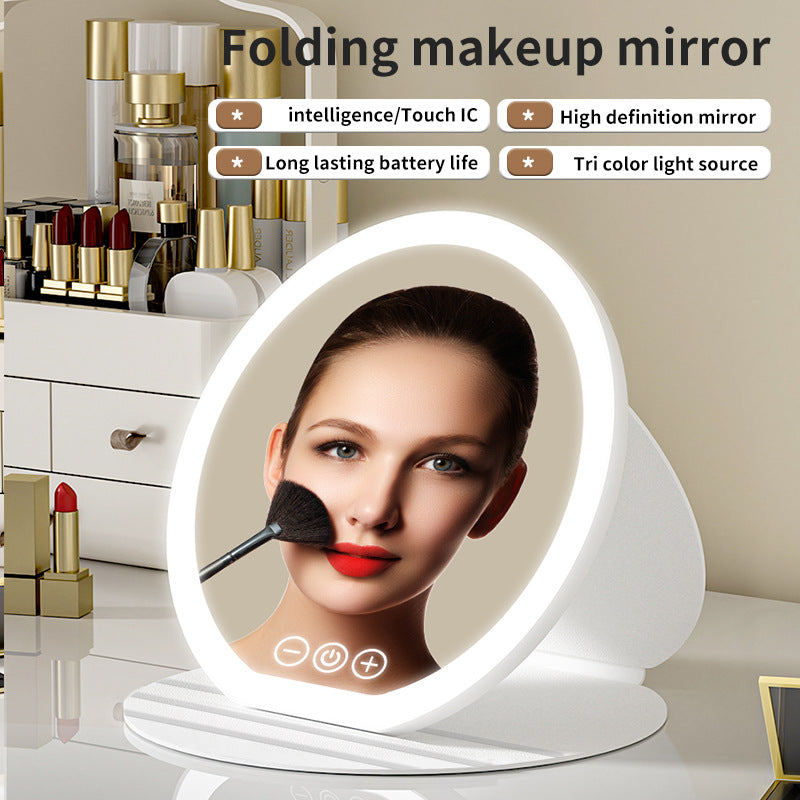 Folding makeup mirror with LED lights on a vanity table with makeup products.