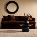 Brown sofa with decorative pillows in a living room setting.