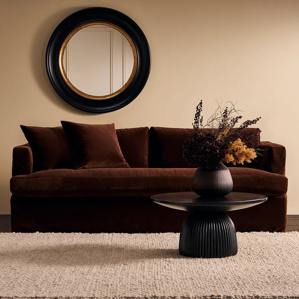 Brown sofa with decorative pillows in a living room setting.