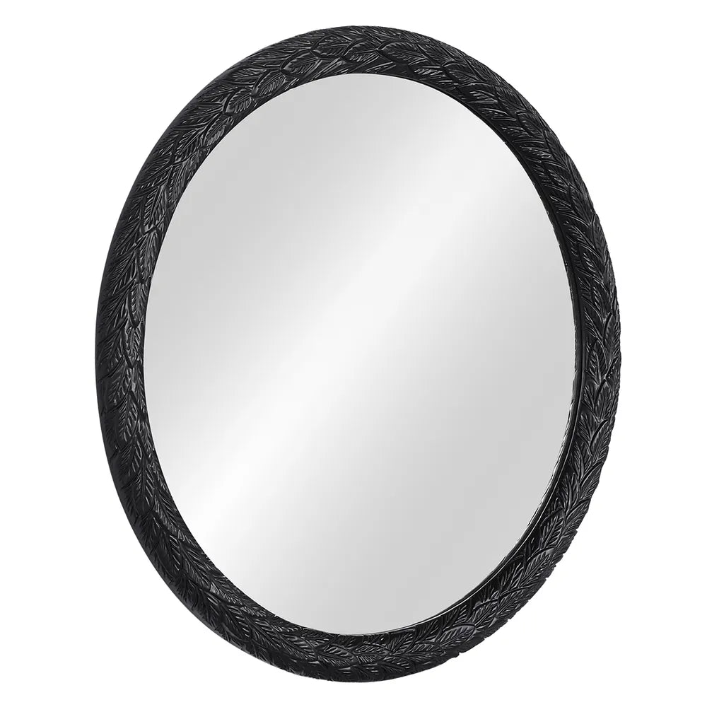Round mirror with decorative black frame on a white background