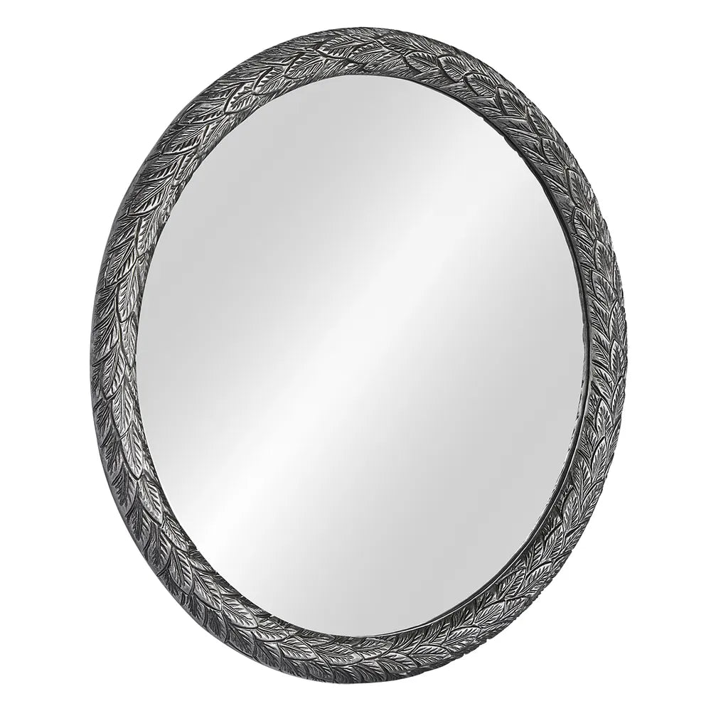 Round mirror with decorative black frame on a white background
