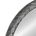 Round mirror with decorative silver frame on a white background