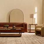Modern living room with brown leather sofa, coffee table, and armchair.